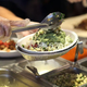Chipotle order counter with ingredients being ladled into burrito bowl